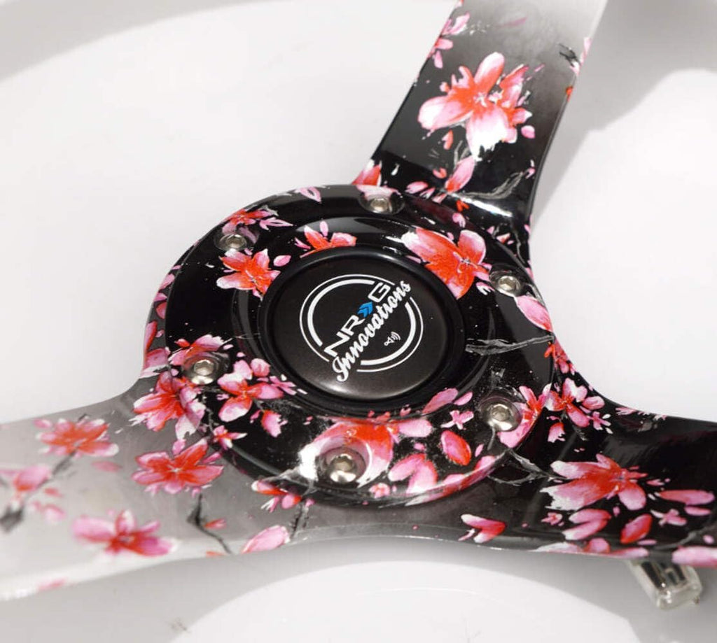 NRG Innovations NRG-RST-036SAK-R Reinforced Steering Wheel, Hydro Dipped Sakura Floral 3' Deep, 5mm Spoke, 350mm, Pink Suede with Black Baseball Stitching